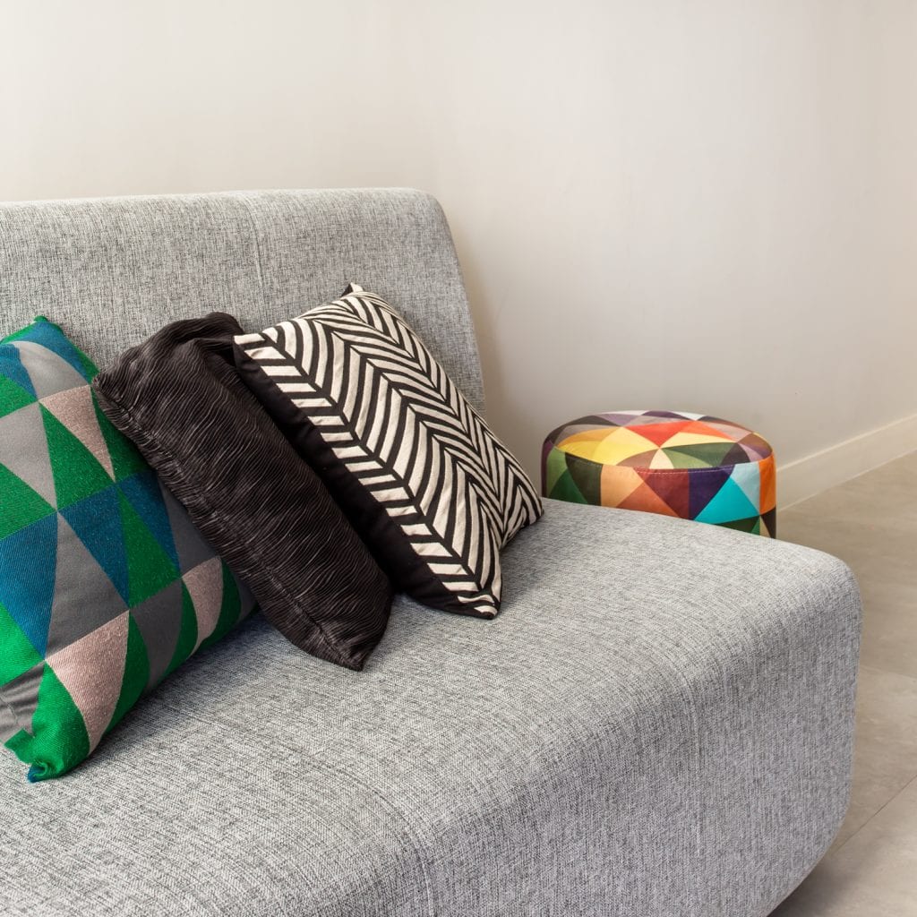 sofá cinza com almofadas coloridas em apartamento despojado