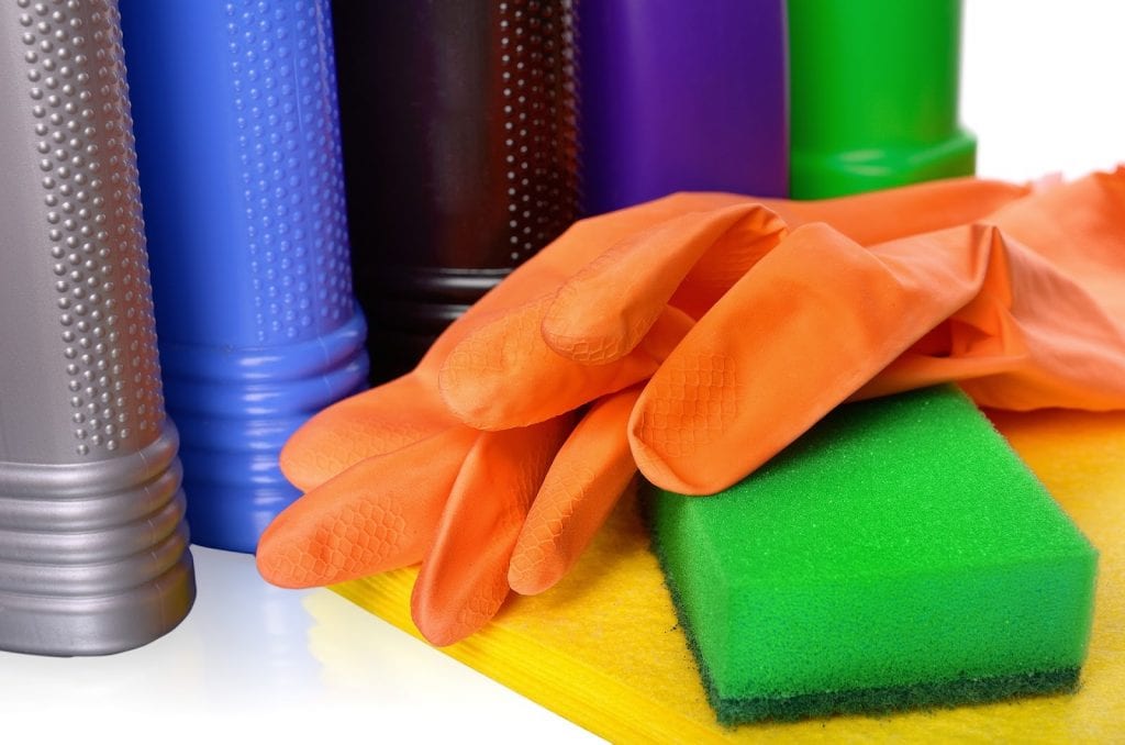 Foto de acessórios para limpeza, com esponja, luvas, frascos e panos. Imagem ilustrativa para texto mistura para limpar sofá.