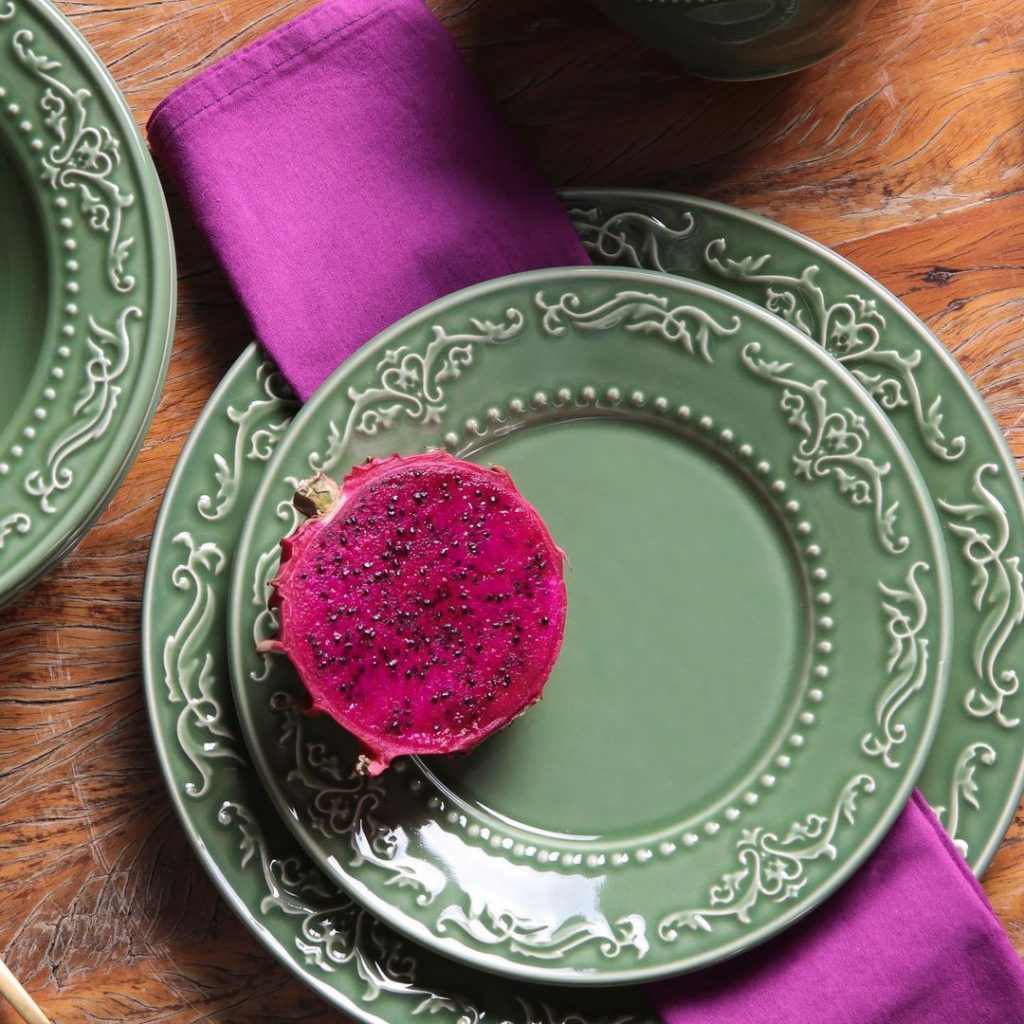 composição de pratos verdes com guardanapo rosa e pitaya